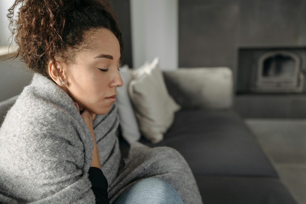woman sitting on a couch, feeling cold